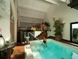 Pequeña piscina de hidroterapia rodeada de plantas en el spa del hotel A Quinta da Auga