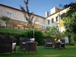 Terraza con sillones de mimbre en el jardín junto al edificio del hotel A Quinta da Auga