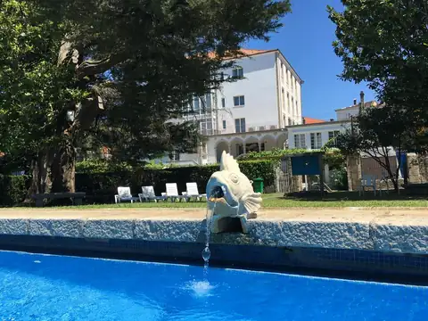 Fuente con forma de pez en la piscina exterior junto al edificio del Balneario Acuña