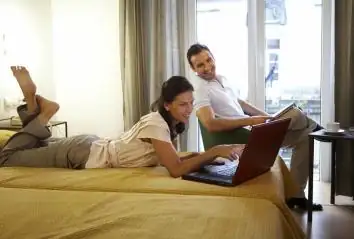 Pareja con portátil en una habitación con ventanal del Balneario Acuña