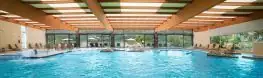 Vista panorámica de la piscina termal cubierta y sus tumbonas en el Balneario Arnoia