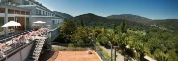 Terraza con sombrillas y vistas a los montes y bosques que rodean el Balneario Arnoia