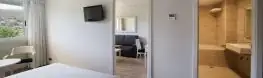 Habitación con dormitorio, zona de estar y baño completo del Arnoia Caldaria Hotel Balneario