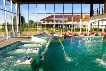 Piscina de hidroterapia con cañones de agua y ventanales al edificio de Augas Santas en Pantón