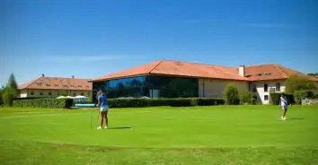 Jugadores en el campo de golf frente al edificio del balneario Iberik Augas Santas en Pantón