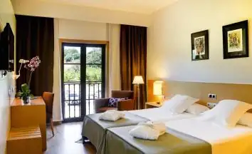 Habitación con dos camas, albornoces y salida a balcón en el hotel Iberik Augas Santas
