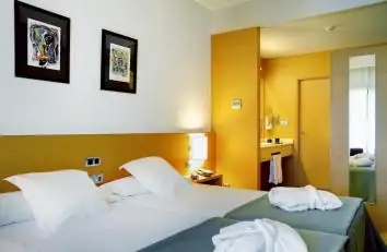 Habitación doble luminosa con camas separadas y cuadros en Iberik Augas Santas Balneario & Golf