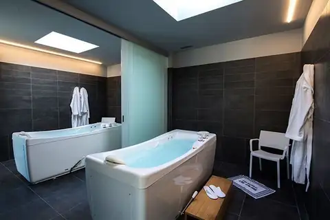Sala de bañeras de hidroterapia individuales con albornoces en el Balneario Caldas de Partovia