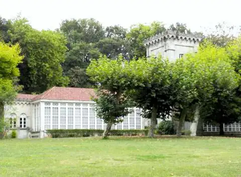 Pabellón acristalado blanco y torre entre jardines y césped del Balneario Caldas de Partovia