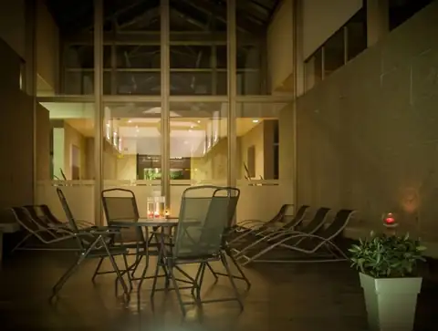 Patio interior con mesas y sillas iluminado por velas en el Hotel Balneario de Compostela