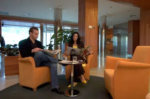 Huéspedes leyendo el periódico en los sillones del salón del Hotel Balneario de Compostela