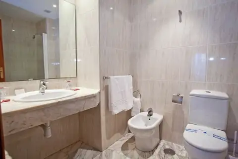 Baño completo con lavabo, bidé e inodoro en una habitación del Hotel Balneario de Carballo