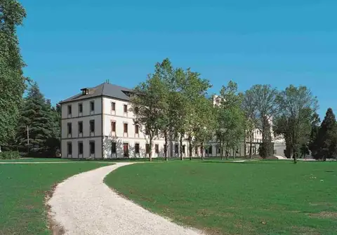 Camino entre praderas y árboles hacia el edificio del Iberik Gran Balneario de Guitiriz & Golf