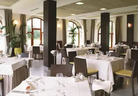 Restaurante con mesas vestidas y ventanales en arco del Iberik Gran Balneario de Guitiriz