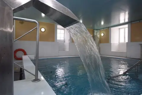 Cañón de agua sobre la piscina termal con barandillas del Hotel Balneario de Lugo