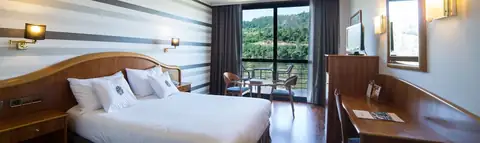 Habitación doble con cama de matrimonio y vistas al bosque en el Laias Caldaria Hotel Balneario