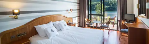 Habitación con cama de matrimonio y terraza con vistas al río en Laias Caldaria