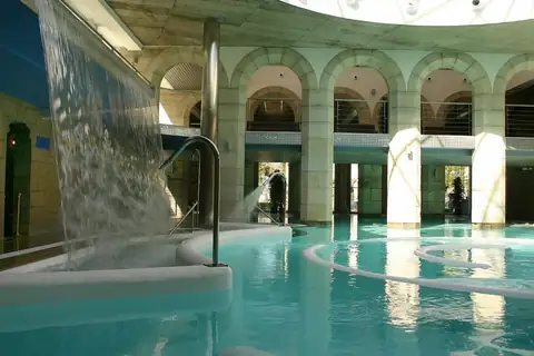 Arcos de piedra y lámina de agua en la galería termal del Balneario de Mondariz