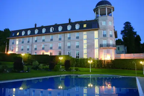 Fachada iluminada al atardecer y piscina exterior del hotel del Balneario de Mondariz