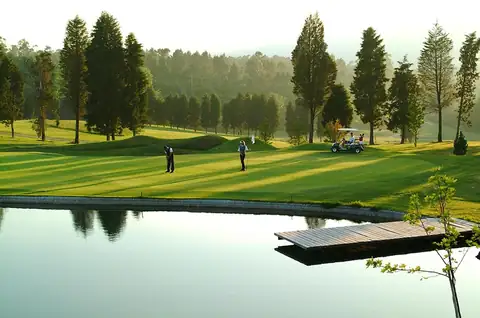 Campo de golf con estanque y bosque de coníferas junto al Balneario de Mondariz