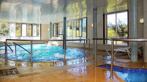Piscina climatizada de hidromasaje con barandillas en el Hotel Balneario Río Pambre