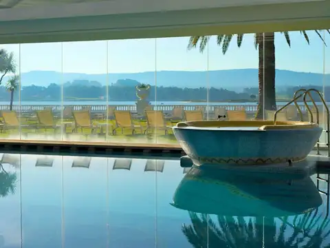 Piscina interior acristalada con vistas a la ría y jacuzzi de mosaico en el Gran Hotel La Toja