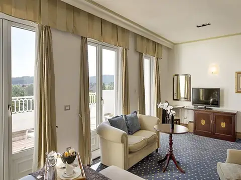 Salón de suite con sofá, televisor y ventanales al balcón en el Eurostars Gran Hotel La Toja