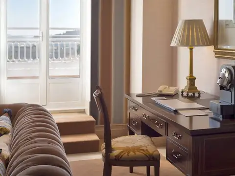 Rincón de trabajo con escritorio clásico y sofá Chester en una habitación del Gran Hotel La Toja
