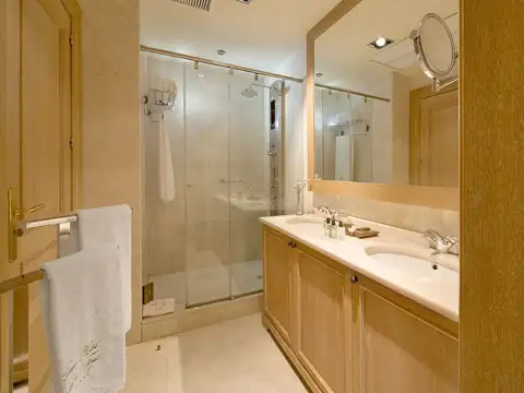 Baño con doble lavabo, ducha acristalada y gran espejo en una habitación del Gran Hotel La Toja