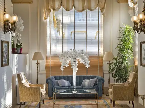 Salón con sofá azul, butacas y centro de orquídeas blancas en el Eurostars Gran Hotel La Toja