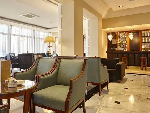 Bar del hotel con butacas tapizadas y suelo de mármol en el Eurostars Gran Hotel La Toja