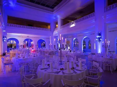 Gran salón de banquetes iluminado en azul con mesas redondas montadas en el Gran Hotel La Toja