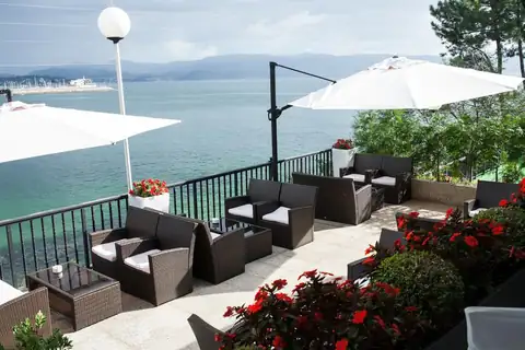Terraza con sombrillas, sofás de exterior y vistas al mar en el Gran Talaso Hotel Sanxenxo