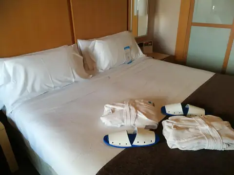 Albornoces y zapatillas de spa preparados sobre la cama en el Gran Talaso Hotel Sanxenxo