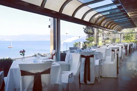 Restaurante acristalado con mesas vestidas y vistas al mar en el Gran Talaso Hotel Sanxenxo