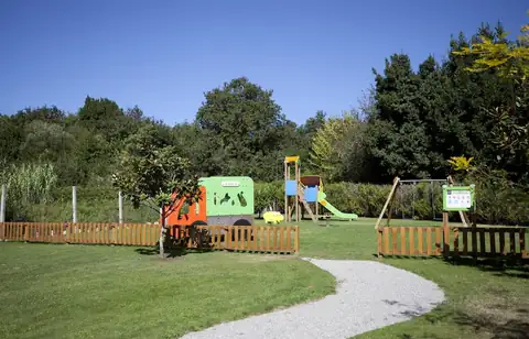 Parque infantil con tobogán y columpios en el jardín del Hotel Carlos I Silgar