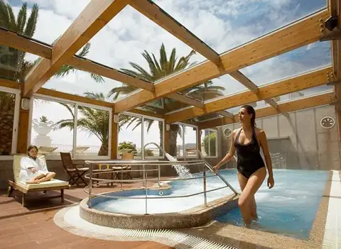 Bañista entrando en el jacuzzi del solárium acristalado del Eurostars Louxo Talaso