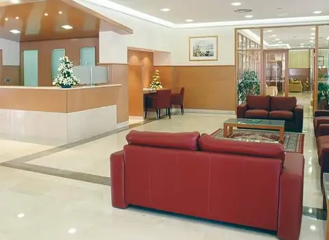 Recepción y salón con sofás rojos en el vestíbulo del Eurostars Louxo Talaso