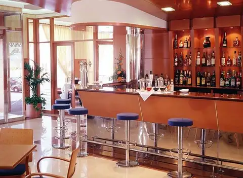 Barra de bar con taburetes y botellero iluminado en el Eurostars Louxo Talaso de La Toja