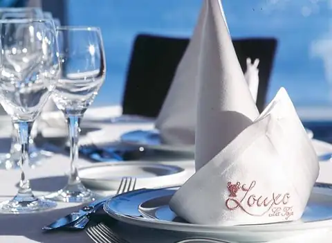 Detalle de mesa montada con copas y servilleta bordada con el logotipo del Louxo La Toja