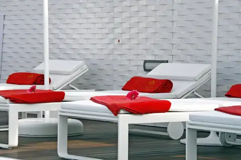 Tumbonas blancas con toallas rojas en la zona de relax del spa del Gran Hotel Nagari