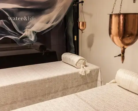 Cabina de tratamientos con dos camillas y cuenco de cobre en el spa del Gran Hotel Nagari