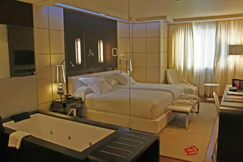 Habitación con bañera de hidromasaje integrada junto a la cama en el Gran Hotel Nagari de Vigo