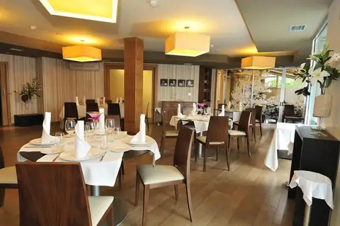 Restaurante con mesas vestidas, sillas de madera y lámparas cálidas del Hotel Norat Marina & Spa
