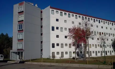 Edificio de apartamentos de varias plantas entre árboles en la Estación de Montaña Manzaneda