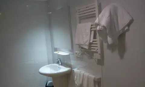 Baño con lavabo y toallero con toallas en los Apartamentos Manzaneda