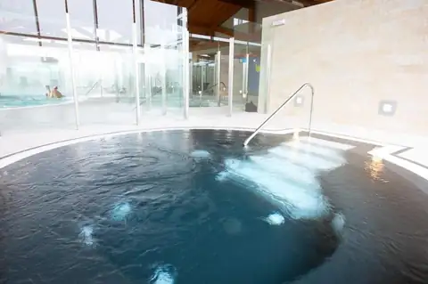 Jacuzzi circular con escalera de acceso en la zona de aguas del Hotel Spa Attica21 Vilalba