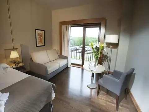 Habitación con sofá, mesita y salida al balcón del Hotel Spa Attica21 Vilalba