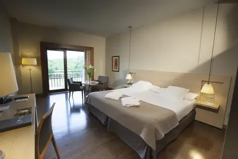 Habitación doble con escritorio y ventanal al exterior en el Attica21 Vilalba