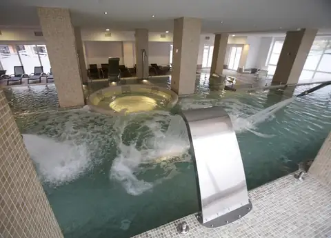 Cascada de acero y jacuzzi circular en la piscina termal del spa del Hotel Bienestar Moaña